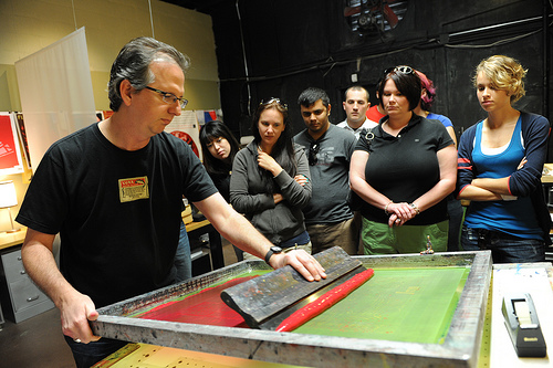 Using a squeege, Jeff floods the entire screen with the ink, making sure that the entire impression area is covered.